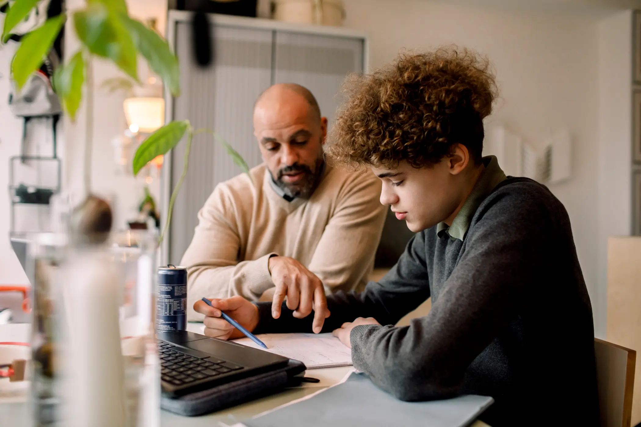 A man and a teenager working through homework.